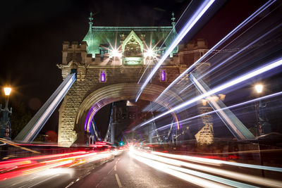 Light trails on bridge in city at night