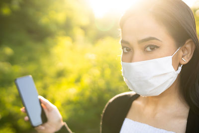 Portrait of woman holding smart phone outdoors