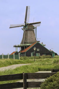 Low angle view of traditional windmill on field against sky