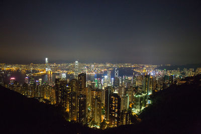 Illuminated buildings in city against sky at night