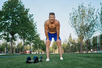 Portrait of shirtless man exercising in park