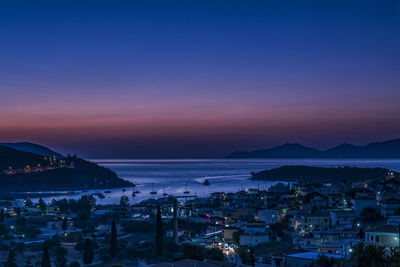 Townscape by sea against sky at dusk