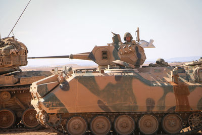 Man in armor tank on land against sky