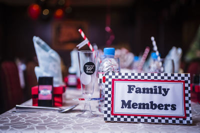 Close-up of family members text on table at restaurant