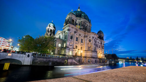 Low angle view of illuminated building against blue sky