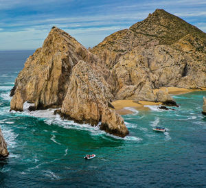 Scenic view of sea and rock formation against sky