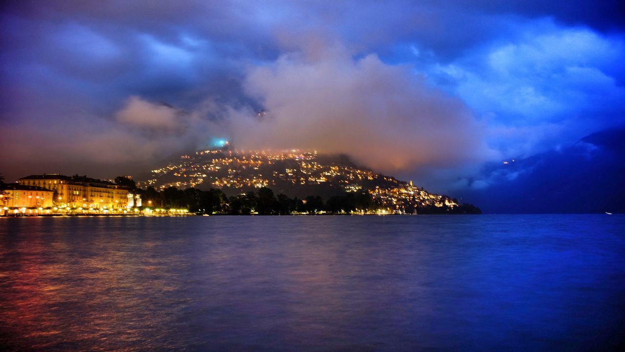 illuminated, night, water, sky, architecture, building exterior, built structure, waterfront, sea, city, cityscape, cloud - sky, scenics, river, reflection, dusk, blue, cloud, outdoors, cloudy