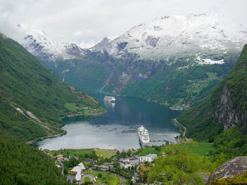 High angle view of lake by snowcapped mountains against sky