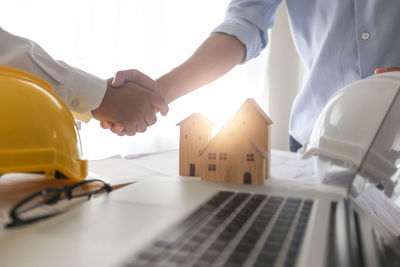 Low section of people holding hands on table