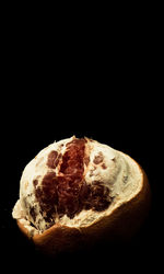 Close-up of rotting fruit against black background