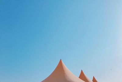 Low angle view of bird flying against clear blue sky