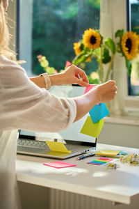 Midsection of woman using laptop on table
