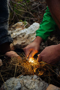 Midsection of man holding fire on land