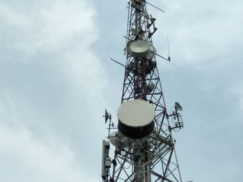 Low angle view of communications tower against sky