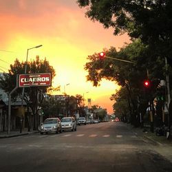 Road in city against sky during sunset