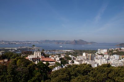 High angle view of buildings by sea against sky