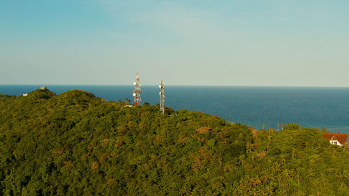 Telecommunication tower, communication antenna in mountains and rainforest, aerial view. 