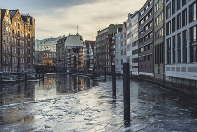 River amidst buildings in city against sky