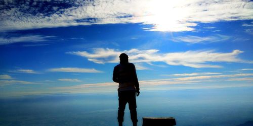 Rear view of silhouette man standing against sky