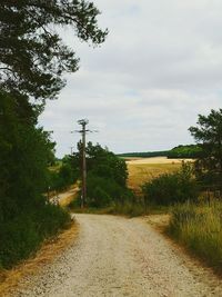 Road amidst field against sky