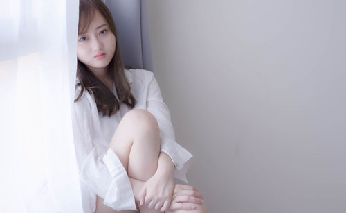 Beautiful young woman sitting at home