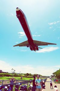 People at airplane against sky