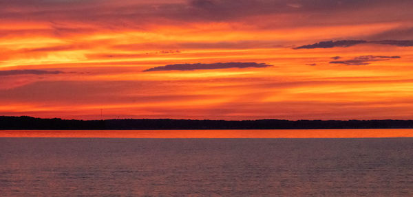 Scenic view of sea against dramatic sky during sunset