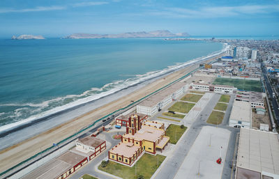 High angle view of cityscape by sea against sky