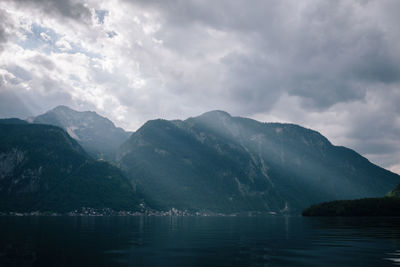 Scenic view of lake by mountains against sky