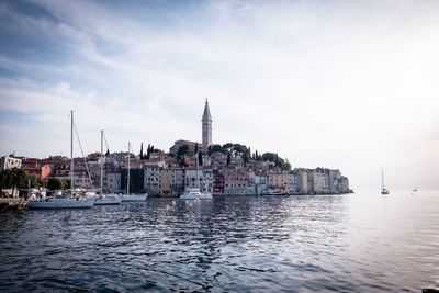 View of buildings by sea against sky