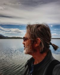 Mature man looking at sea against sky