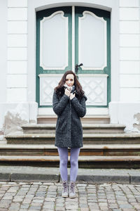 Portrait of young woman leaning on wall