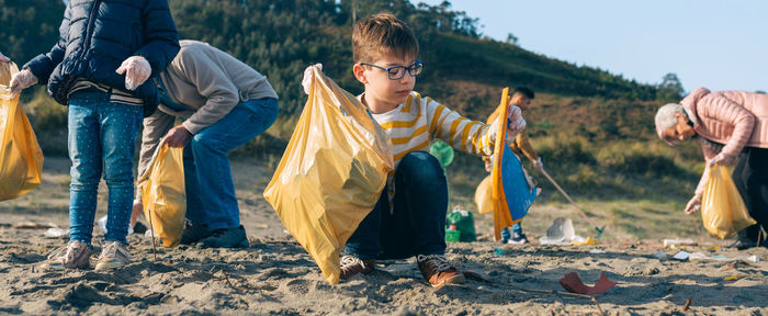 Grandparents and grandchildren cleaning at beach