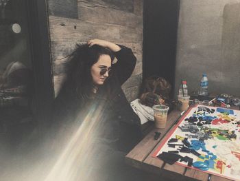 Thoughtful young woman sitting by game on table