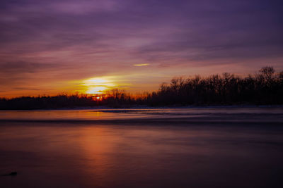 Scenic view of lake against romantic sky at sunset