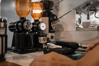 Cropped image of hand holding coffee at cafe