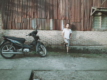 Full length of woman with bicycle standing in building