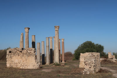 Built structure on field against clear blue sky