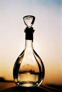 Close-up of bottle against sunset sky