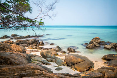 Rocks on beach against clear sky