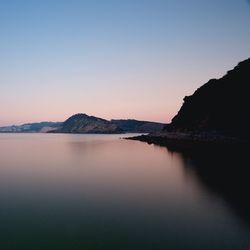 Scenic view of lake against sky at sunset