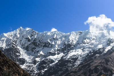 Scenic view of snowcapped mountains against blue sky