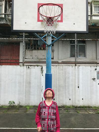 Senior woman standing below basketball hoop