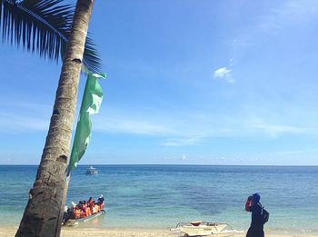 People at beach against blue sky