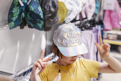 Girl trying baseball cap in shop