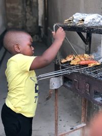 Midsection of man preparing food on barbecue grill