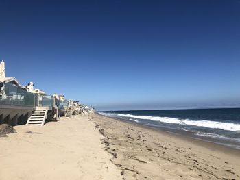 Scenic view of beach against clear blue sky