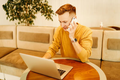 Happy smiling cool young business man freelance student working with wireless technology in a cafe