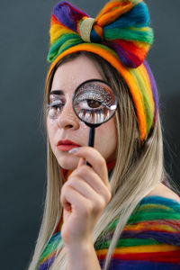 Portrait of young woman looking through magnifying glass