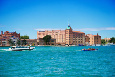 Boats in sea against buildings in city